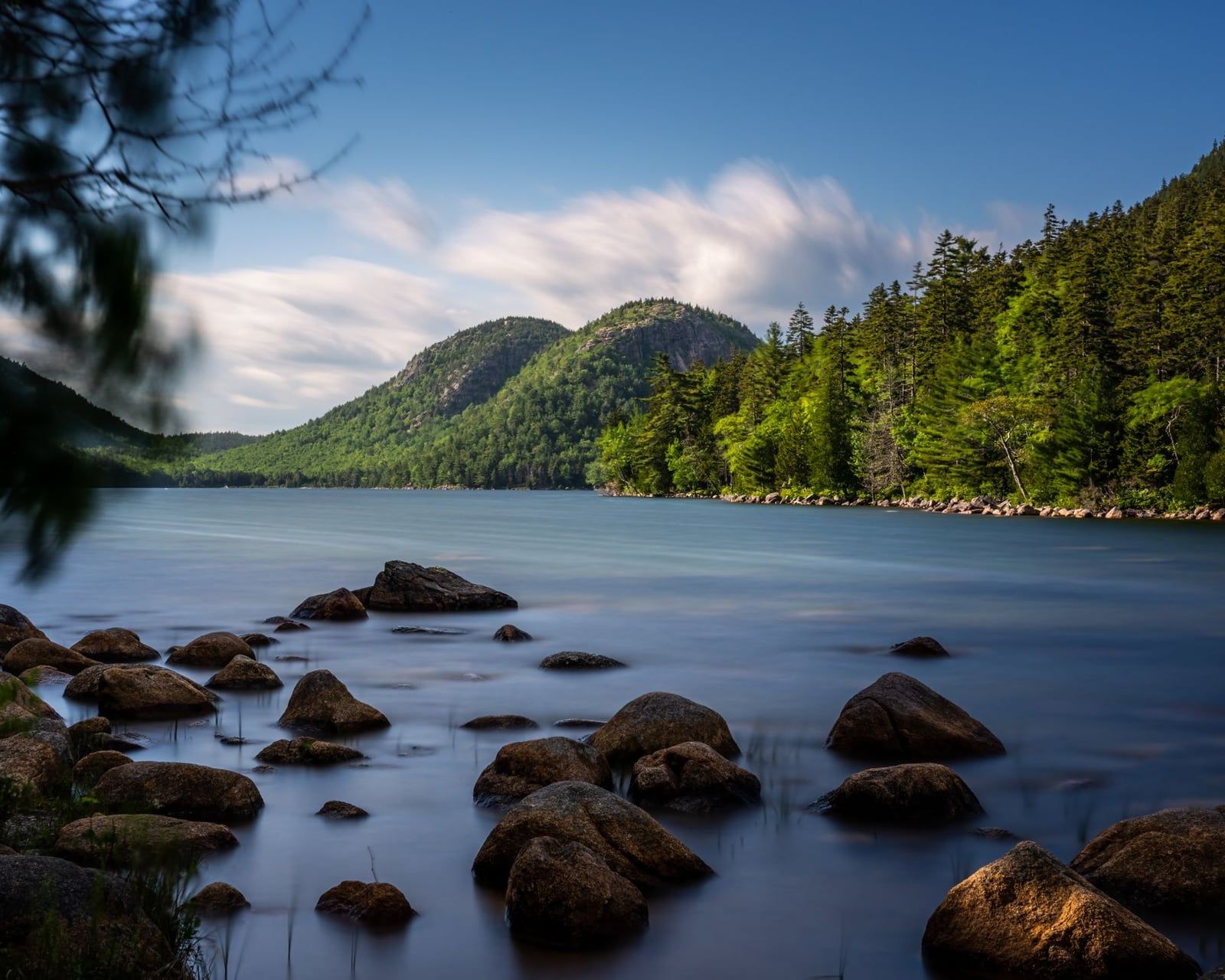 Felsbrocken liegen am Ufer des Jordan Pond unter den Zwillingsbergen Bubble im Acadia-Nationalpark.
